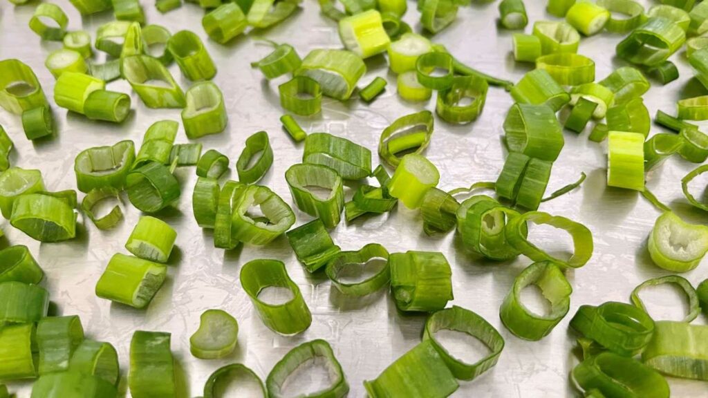 Fresh sliced green onions on a freeze dryer tray waiting to be dried for backpacking meals