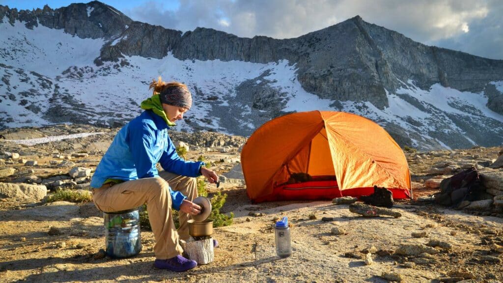 Backcountry Foodie Blog How to Plan Food for First Backpacking Trip woman backpacker hiking food with pot