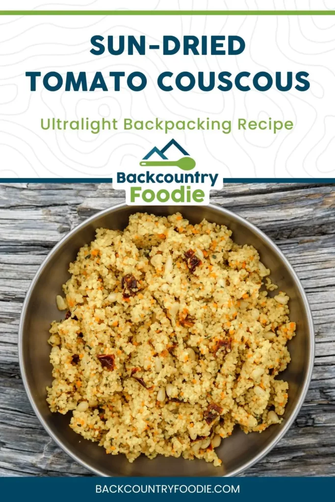 Pinterest graphic of a sun-dried tomato couscous backpacking recipe from Backcountry Foodie. A metal bowl of couscous with pine nuts and sun-dried tomatoes sits on a rustic wood surface. Text overlay reads “Sun-Dried Tomato Couscous – Ultralight Backpacking Recipe.