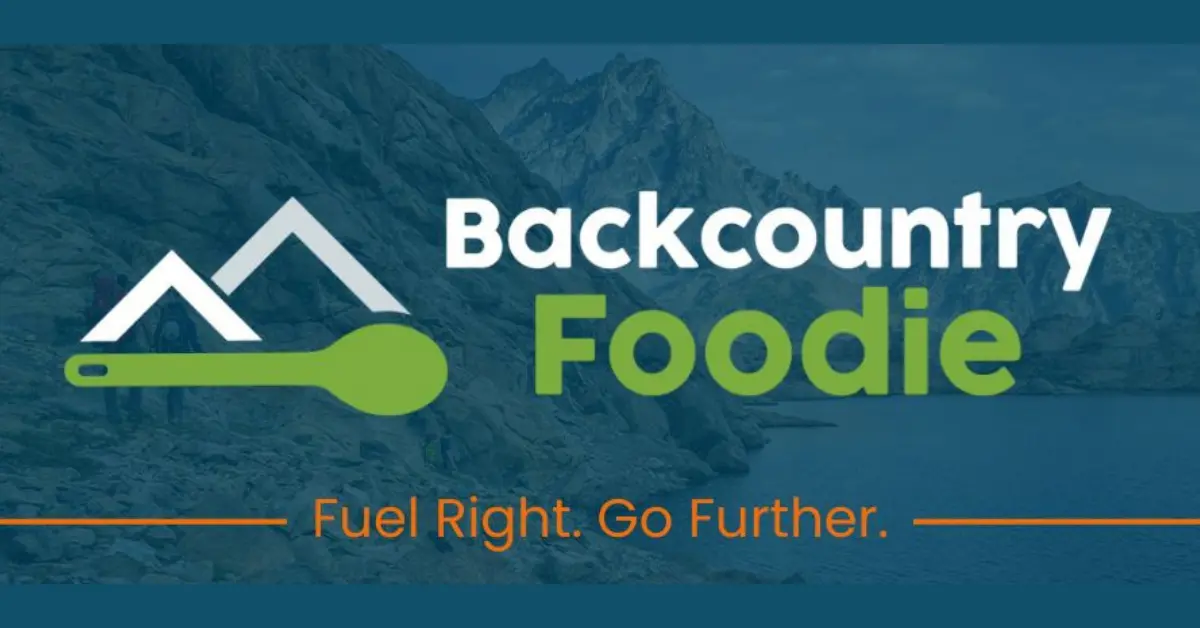 Backcountry Foodie logo featuring mountain peaks and a green spoon, with the tagline "Fuel Right. Go Further." over a scenic mountain background.