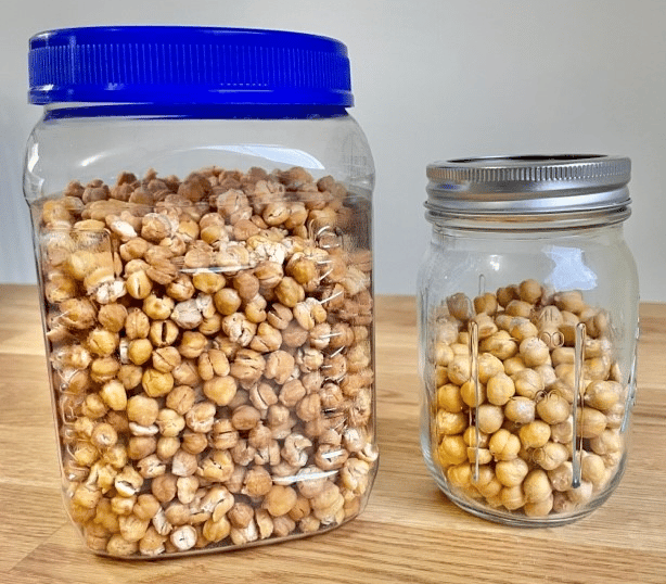 Large plastic container filled with dried chickpeas use for short-term storage and glass mason jar with freeze-dried chickpeas used for long-term storage.