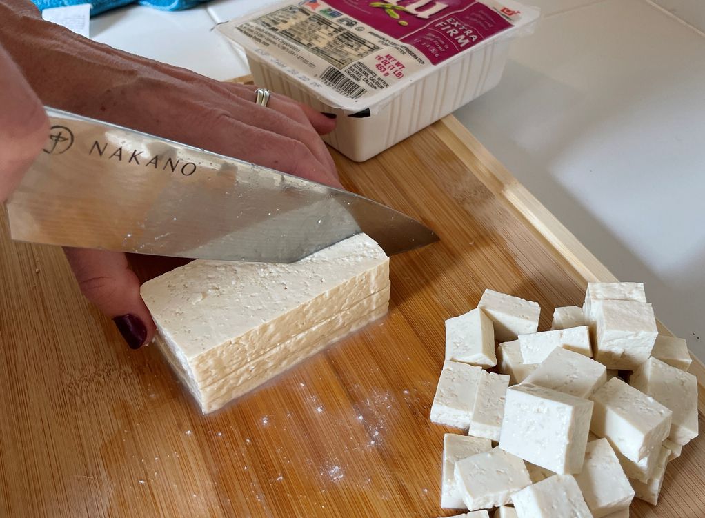 Fresh tofu being sliced in preparation for dehydration for backpacking meals