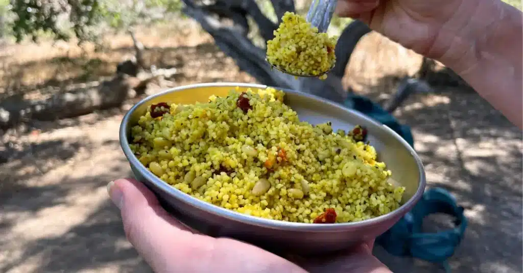 sun dried tomato couscous hiker holding plate spoon social media image